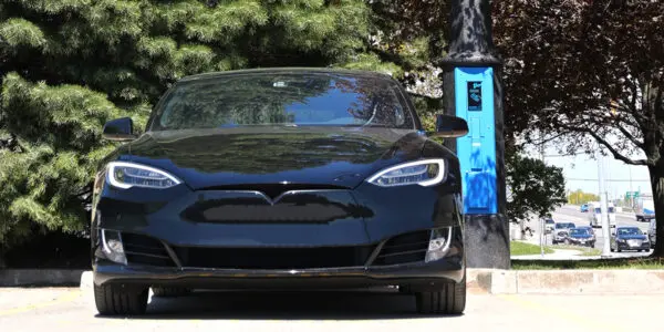 A black car utilizing some of the features offered by the VoltLock EV Charger pole.
