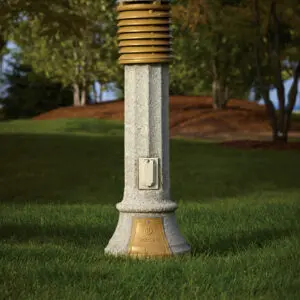 A lit Traditional style bollard finished with gold accents and one of our signature concrete décor colors - Pearl Gray.