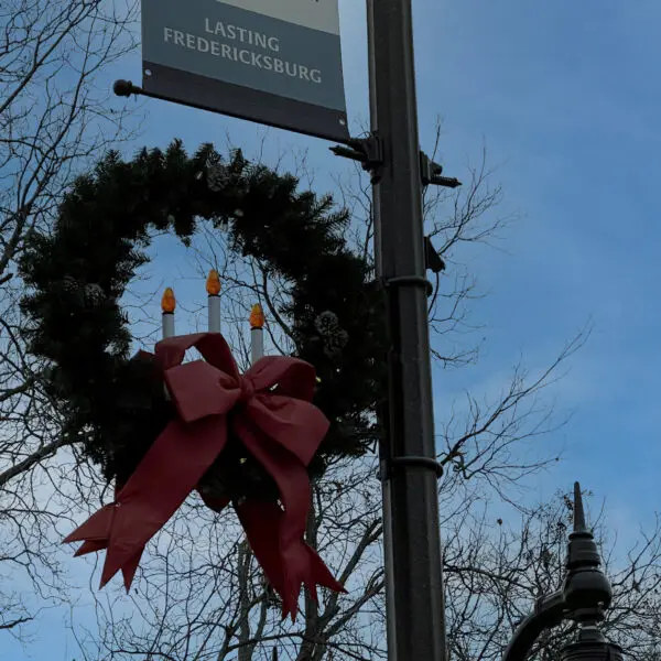 K807 Doral Sr. and K707 Doral Jr. pendants accompanied by a KA30 scroll arm with decorative scroll, two KA40 mini scroll arms with decorative scrolls, and banner arms atop a Washington style pole. This project is in Fredericksburg, Texas during Christmas time.
