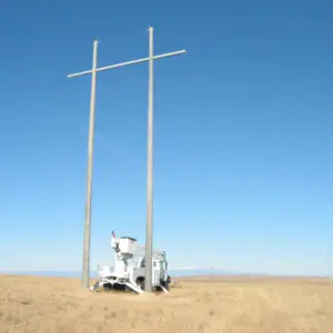 A spun concrete utility pole with an 'H Structure' application. This project is in a flat, farmland area with mountains in the background.