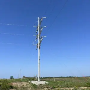 Utility Pole - Angle A spun concrete utility pole with an 'angle' application. This project is in a flat, grassy area.
