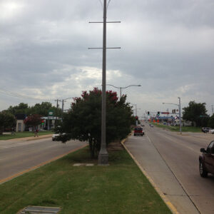 Light fixtures accompanied by banner arms and Pipe style arms on top of a Centennial pole.