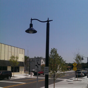 A K208 Moderne fixture accompanied by a pipe style arm on a Belmont pole.