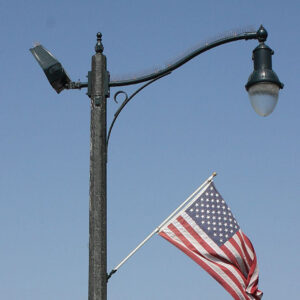 A K803 Solitaire Sr. accompanied by a scroll style arm and flag mount all on top of a Talisman pole.