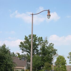 A K804 Coronet Sr. fixture accompanied by a pipe style arm all on a Round Tapered pole.