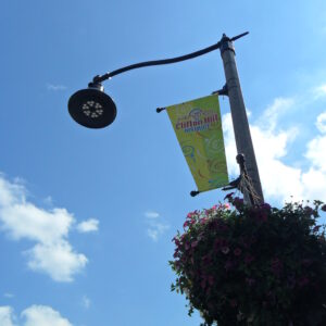 A K829 Aurora Sr. fixture accompanied by a pipe style arm, banner arms all on a Fluted Tapered pole, and flowerpot holders. This project is in Clifton Hills, located in Niagara Falls, Ontario.