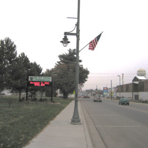 A K366 Harbor Side fixture accompanied by a Marina style arm, banner arms, and a flag mount all on a Kensington pole. Project is in Pine City, Minnesota on a busy street.