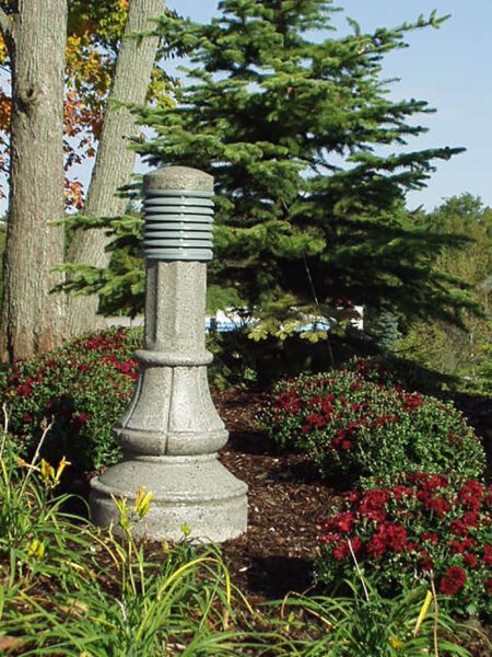 A lit Washington style bollard finished with one of our signature concrete décor colors - Pearl Gray.