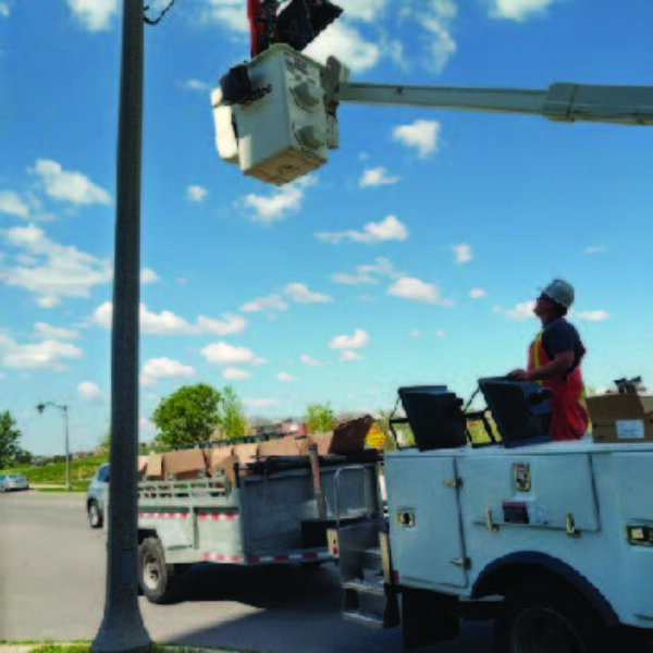 Utility workers installing one of the many K601D Coach Lantern pendant fixtures in Oakville, Ontario.