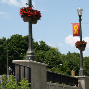 Multiple K124 Paragon fixtures accompanied by banner arms and flowerpot arms atop of a Talisman pole. This project is next to busy road in Canada.