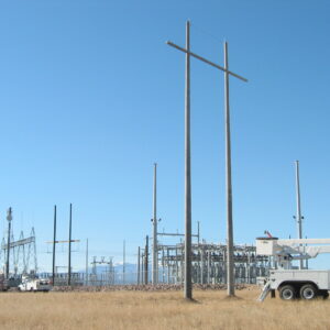A spun concrete utility pole with an 'H Structure' application. This project is in a flat, farmland area with mountains in the background.