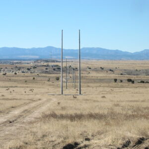 Spun concrete utility poles with a 'tangent' application. This project is in a flat, remote area with mountains in the background.